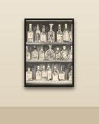 Estantería de botellas en una pared clara con marco negro (imagen ilustrativa)