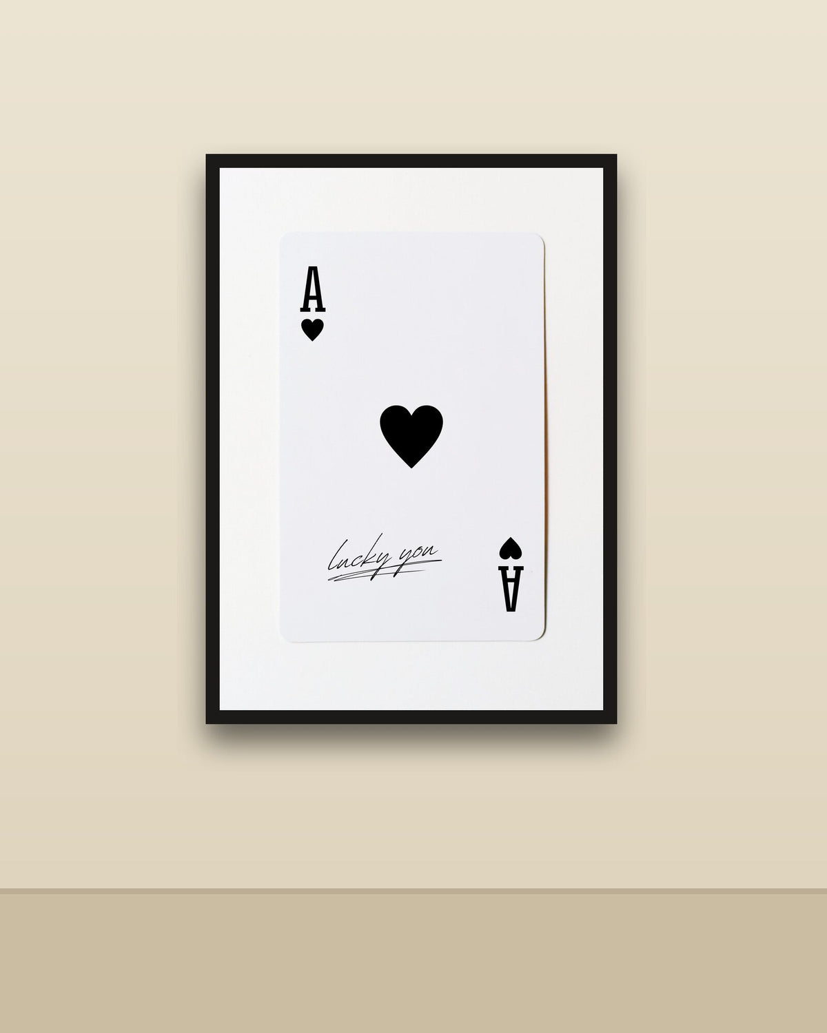 As de corazones en una pared clara con marco negro (imagen ilustrativa)