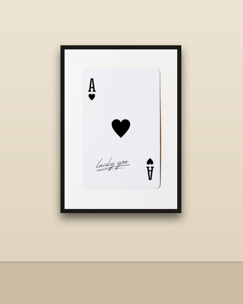 As de corazones en una pared clara con marco negro (imagen ilustrativa)