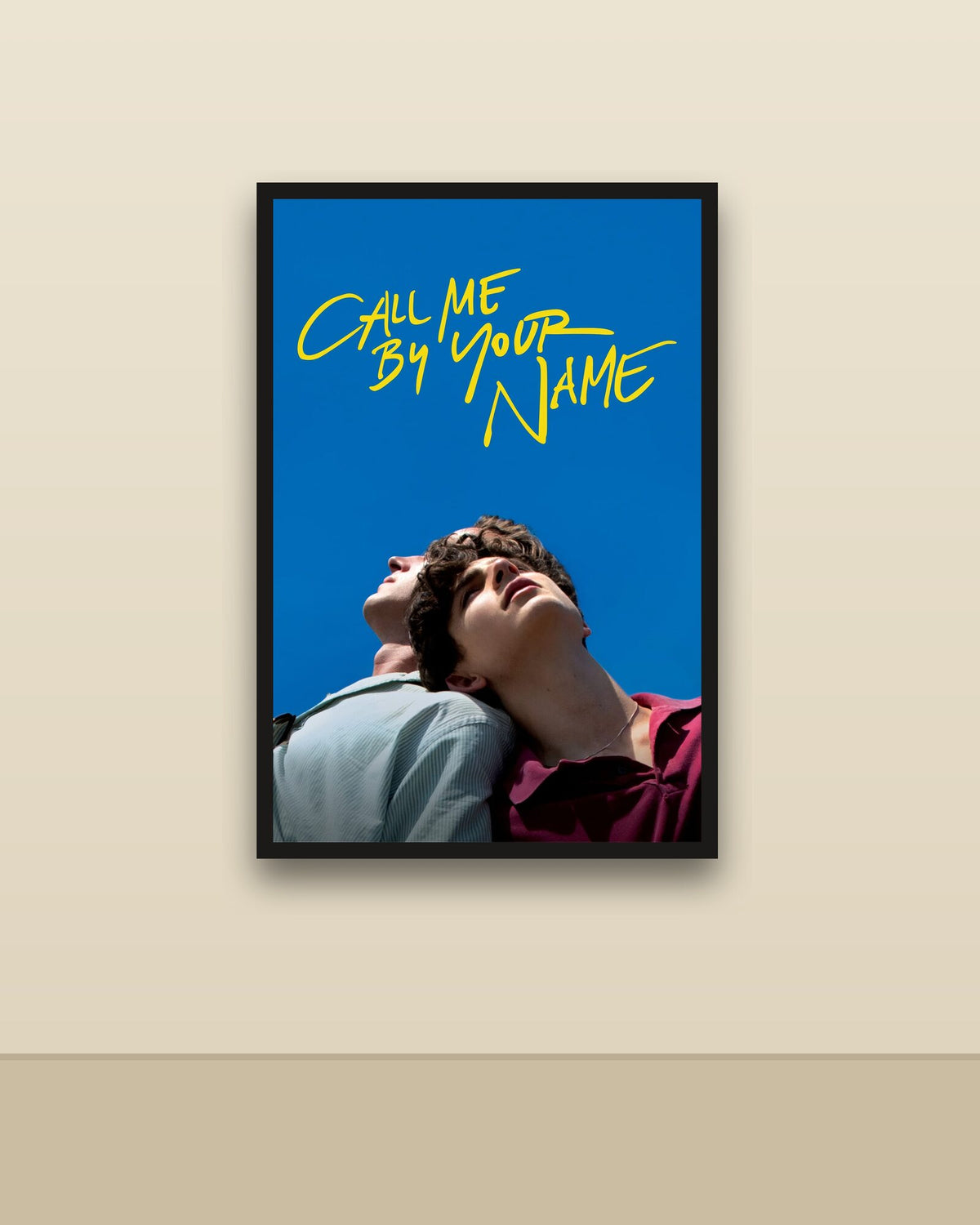 Call Me by Your Name en una pared clara con marco negro (imagen ilustrativa)